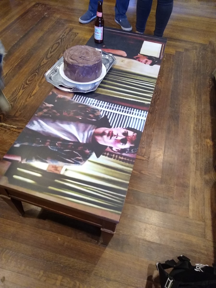 Coffee table with fake chocolate cake and empty bottle. 